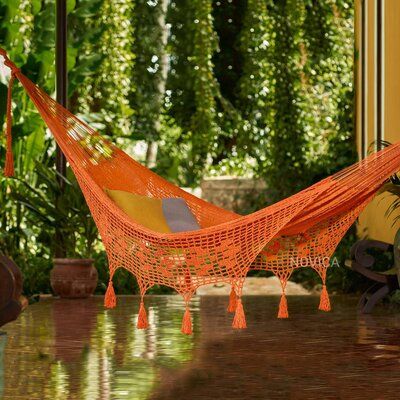 an orange hammock sitting on top of a wooden table