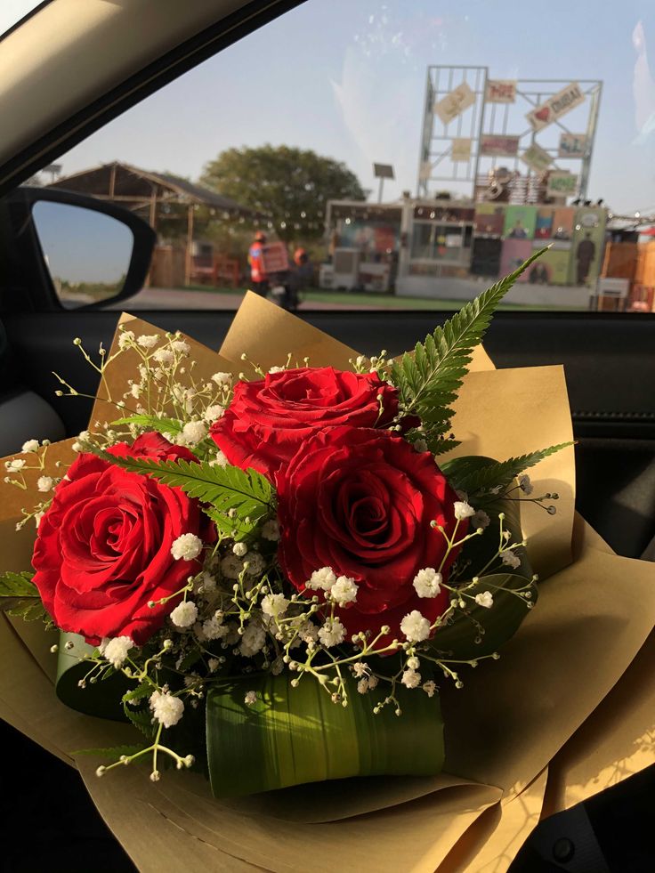 a bouquet of red roses sitting in the back seat of a car