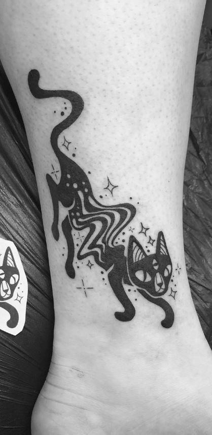 a black and white cat tattoo on the ankle, with stars around its neck area