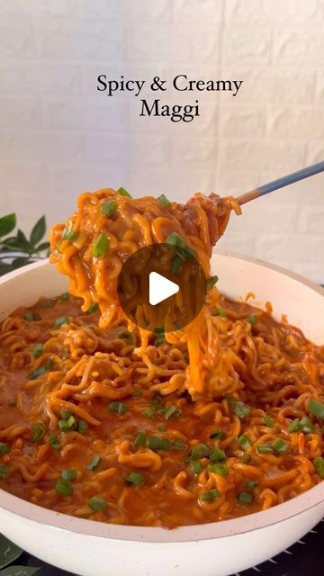 a bowl filled with noodles and sauce being stirred by a wooden spoon on top of it