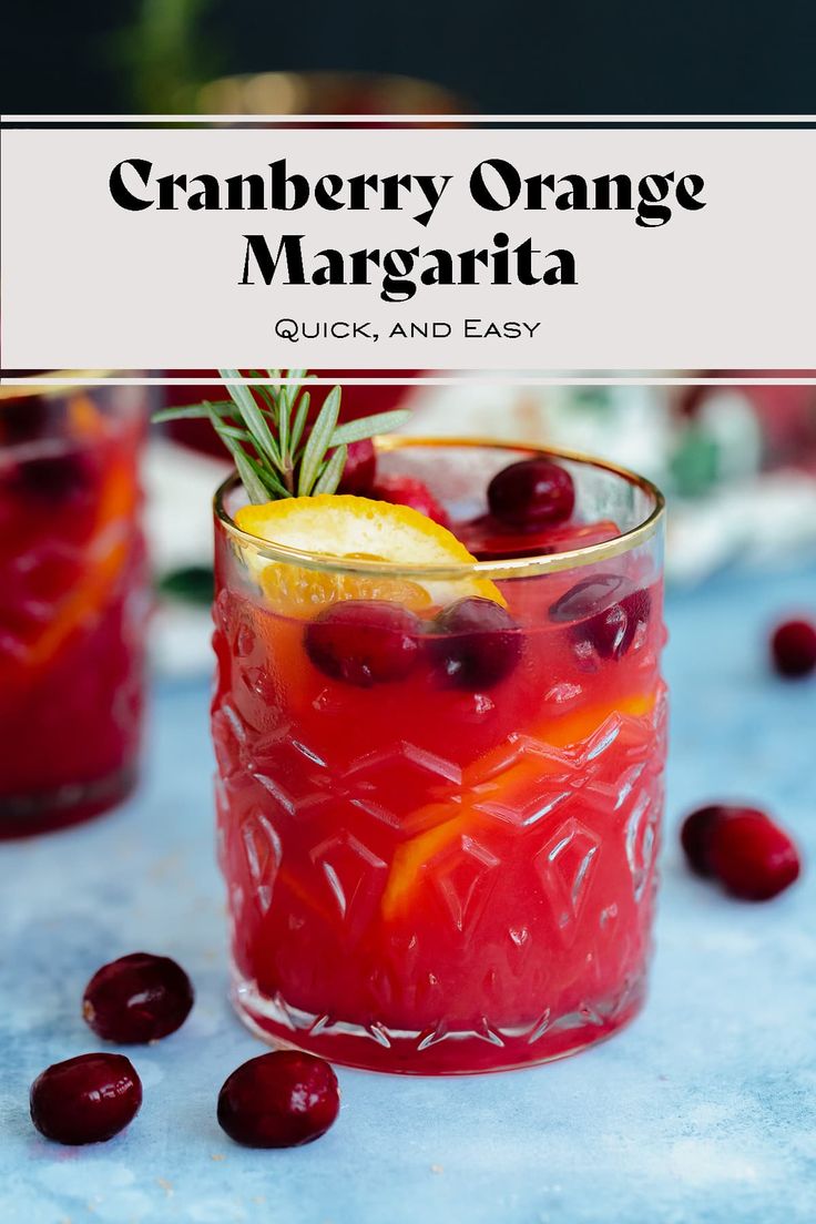 cranberry orange margarita in a glass garnished with an orange slice and rosemary