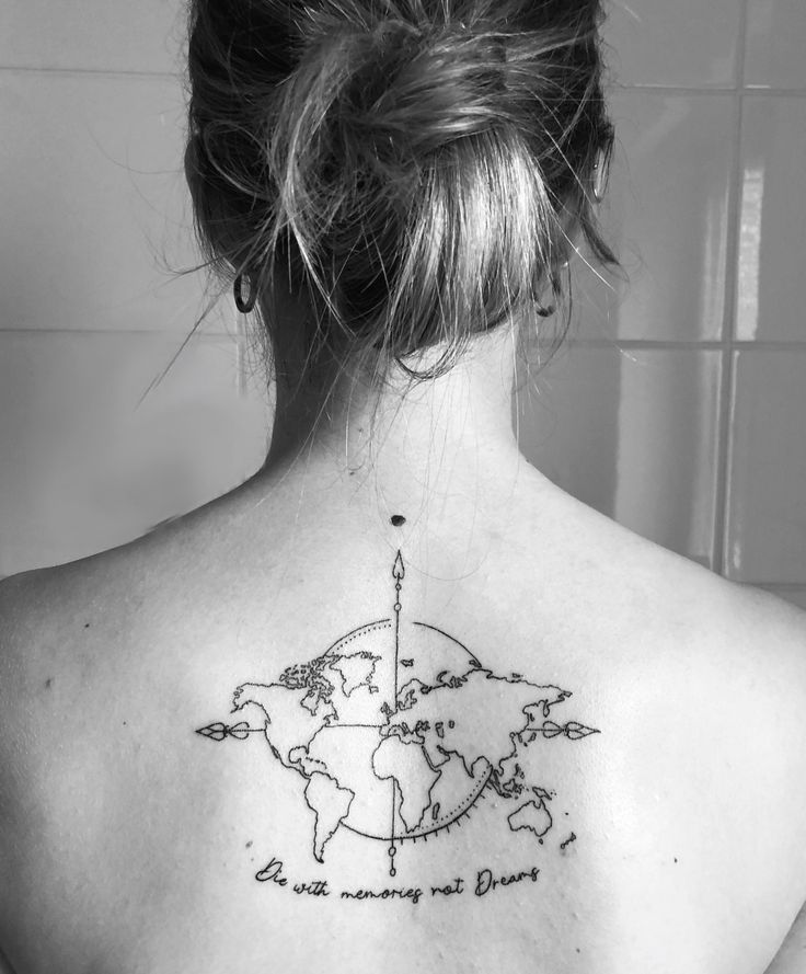 the back of a woman's neck with a world map tattoo on her left shoulder