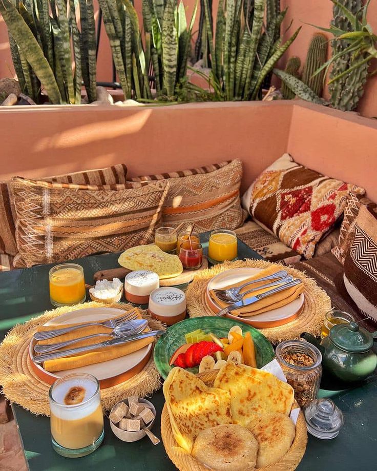 an outdoor table with food and drinks on it