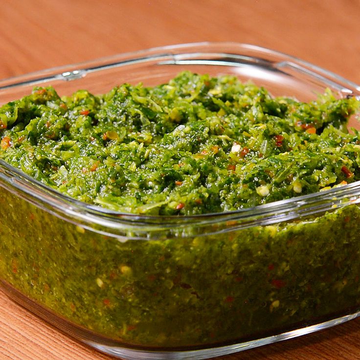 a glass dish filled with green pesto