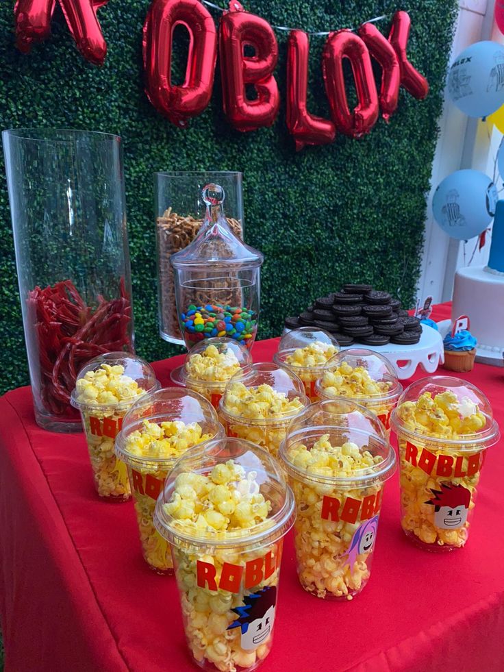 popcorn buckets are sitting on a red table