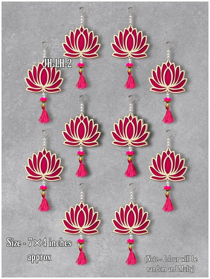 six red and white lotus earrings with tassels on each earring, hanging from hooks