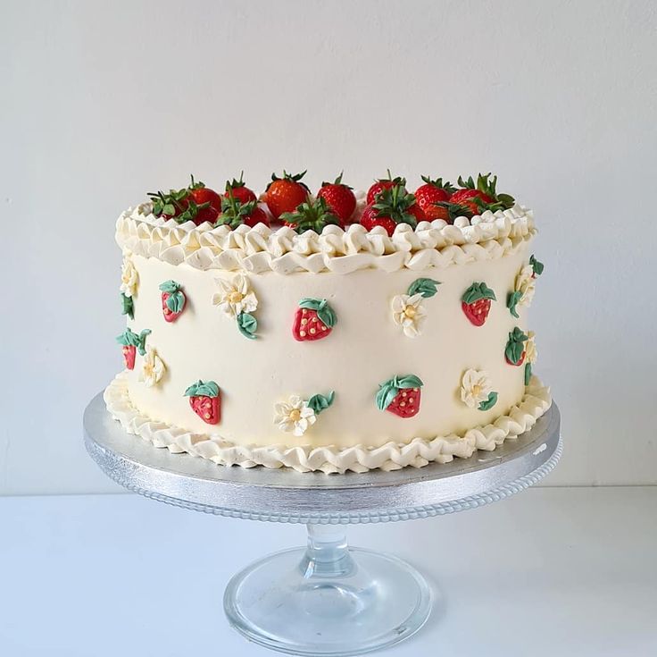 a white cake with strawberries and flowers on it