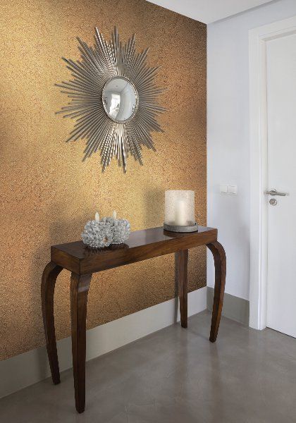 a wooden table with a candle on it in front of a wall decorated with sunbursts