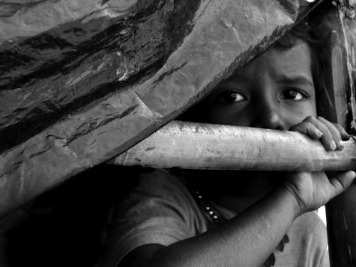 a young boy is holding onto a large piece of wood and looking up at the camera