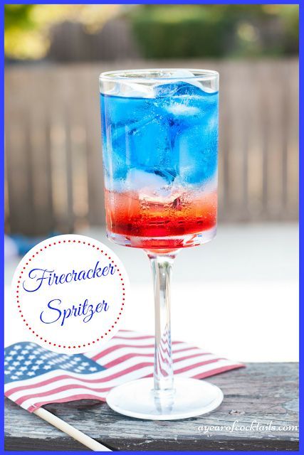 a red, white and blue drink sitting on top of a table next to an american flag