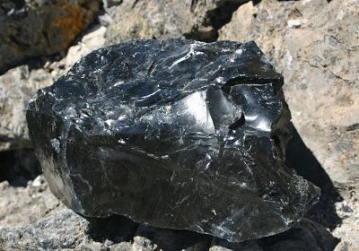 a black rock sitting on top of some rocks