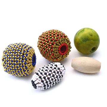 four beaded balls and two pears on a white surface