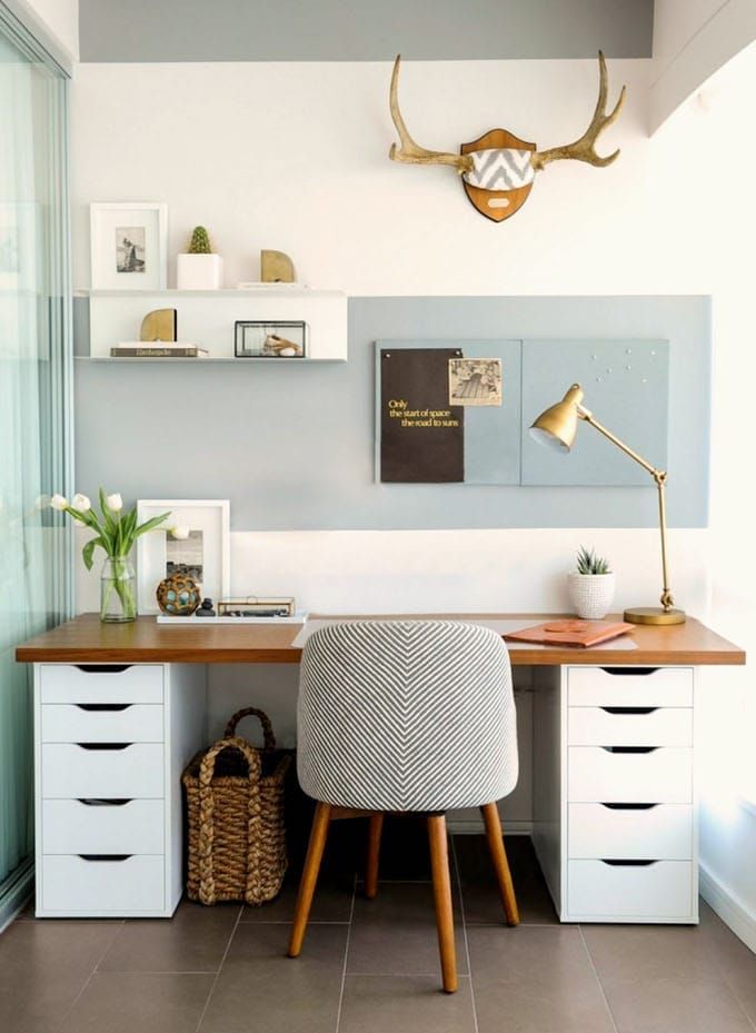 a white desk topped with a chair next to a wall mounted antelope head