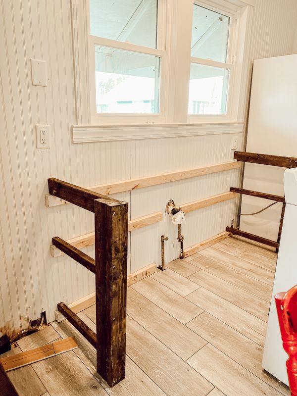 a kitchen with white walls and wood floors