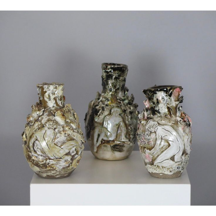 three vases sitting on top of a white shelf