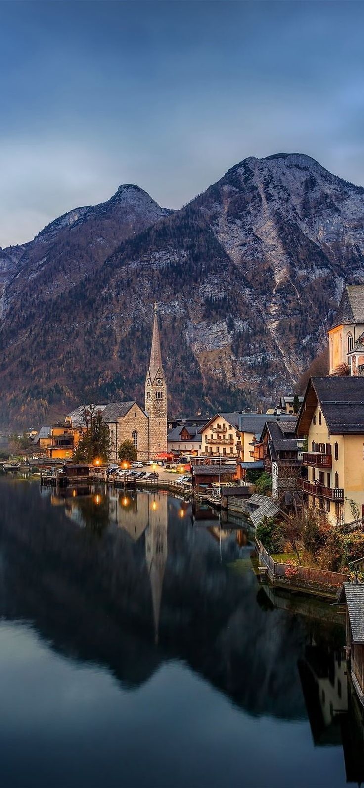 a town with mountains in the background and a body of water surrounded by small houses