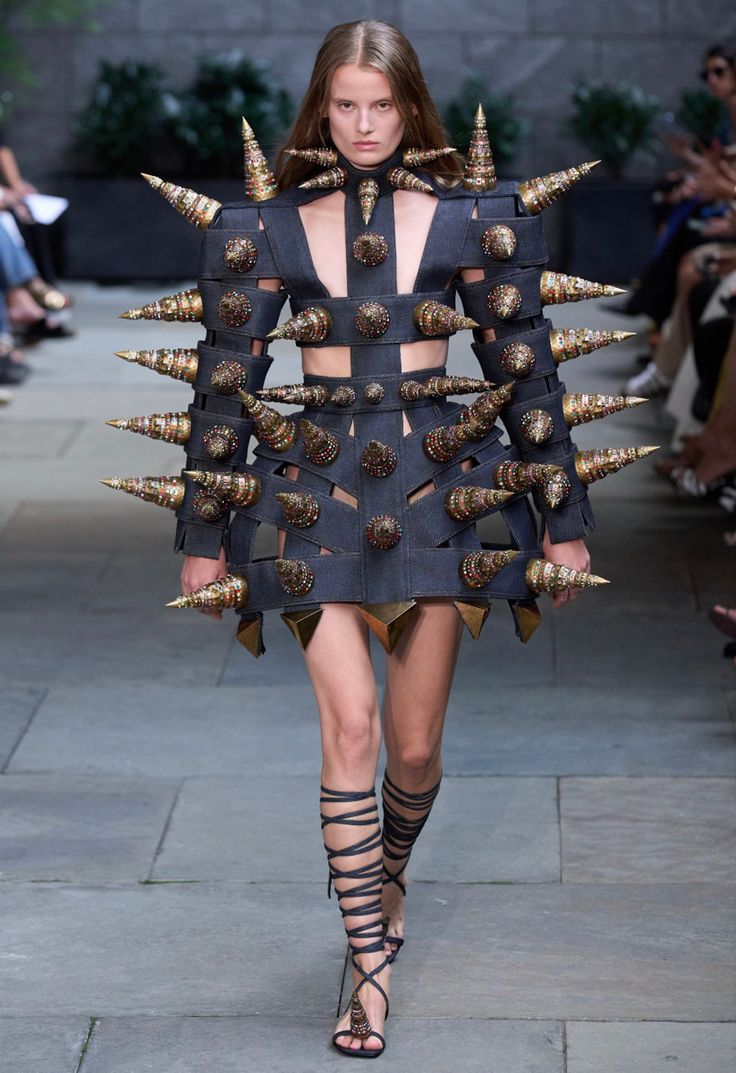 a model walks down the runway in a dress with spikes on it