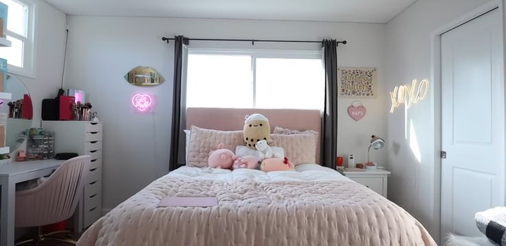 a bedroom with pink bedding and white walls