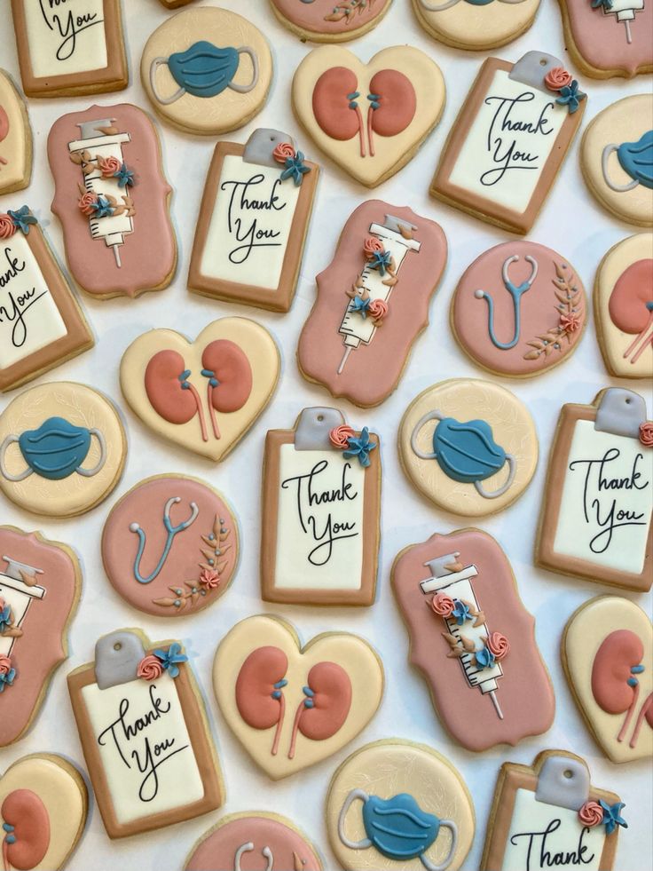 decorated cookies with thank you written on them are displayed in front of a white tablecloth