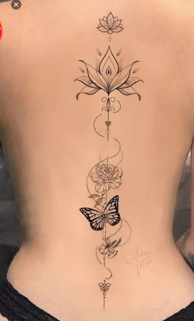 the back of a woman's body with flowers and butterflies tattoo on her lower back