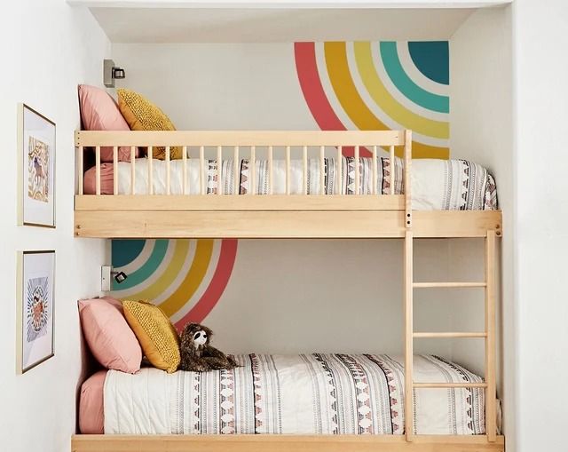 there are two bunk beds in this room with colorful circles on the wall behind them