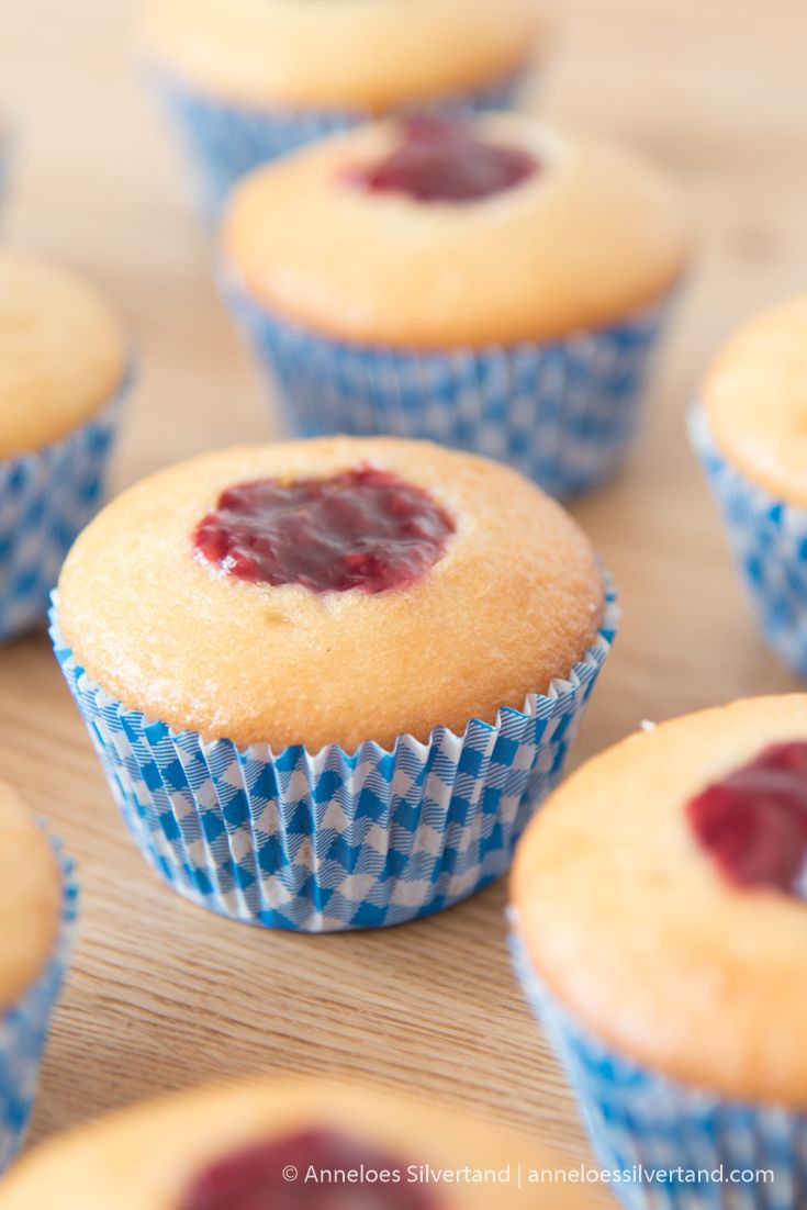 some muffins with jam on them sitting on a table