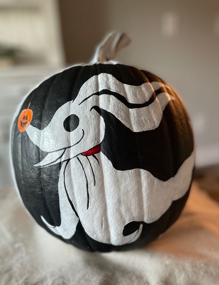 a black and white painted pumpkin with an image of a dog on it's face