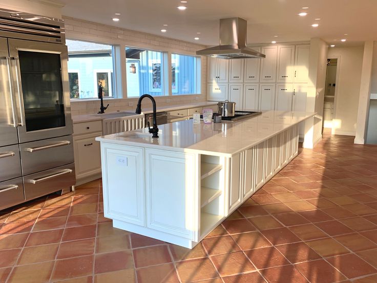 a large kitchen with tile flooring and stainless steel appliances