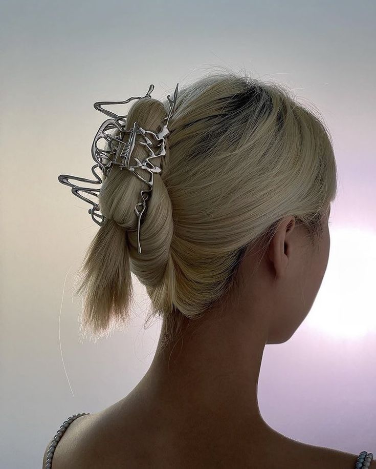 a woman with blonde hair wearing a metal head piece