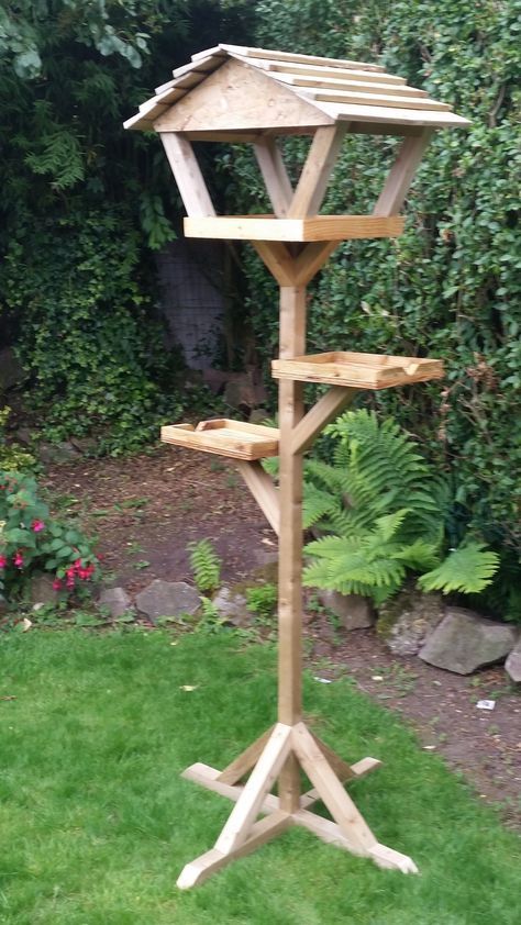 a wooden bird house in the grass