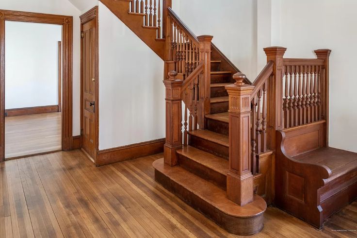 a wooden stair case in an empty room