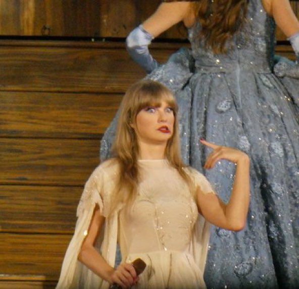 a woman in a blue dress standing next to a mannequin