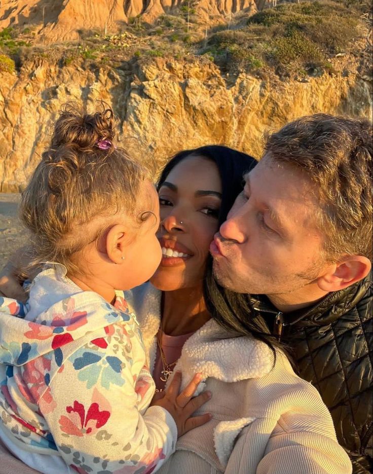 a man, woman and child are taking a selfie in front of the mountains