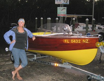 a woman standing next to a yellow and brown boat