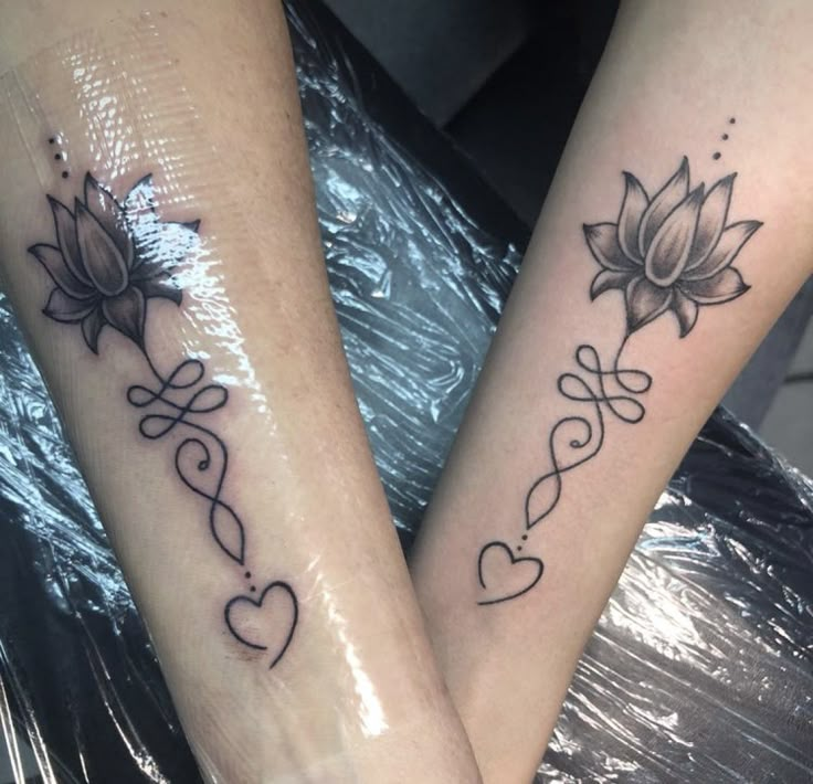 two people with matching tattoos on their legs, both have hearts and lotuses tattooed on them