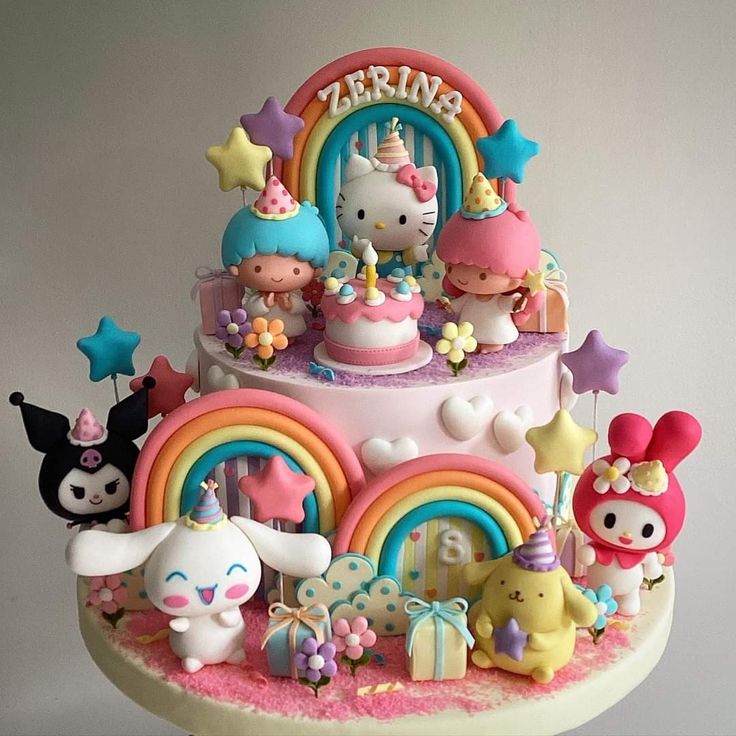 a hello kitty birthday cake is decorated with rainbows, stars, and other decorations