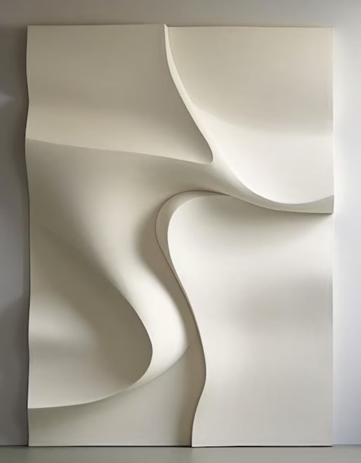 an abstract white sculpture is shown against a wall