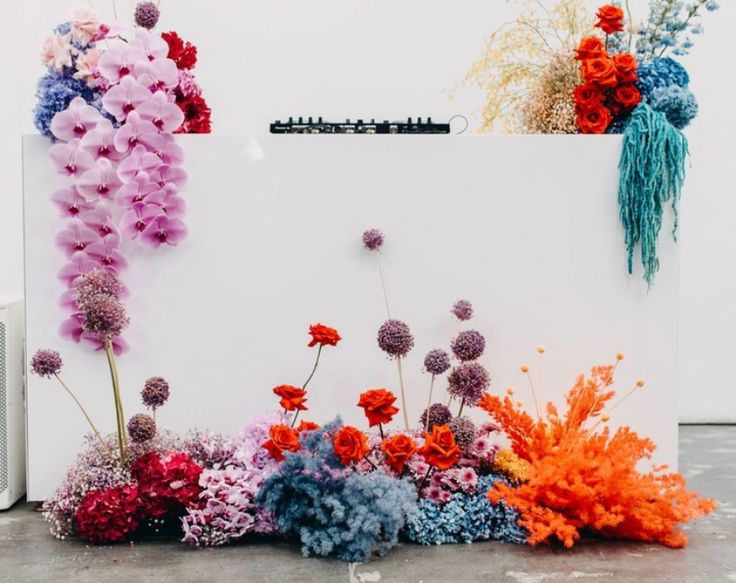 colorful flowers are placed on the side of a white box with an electronic device in it