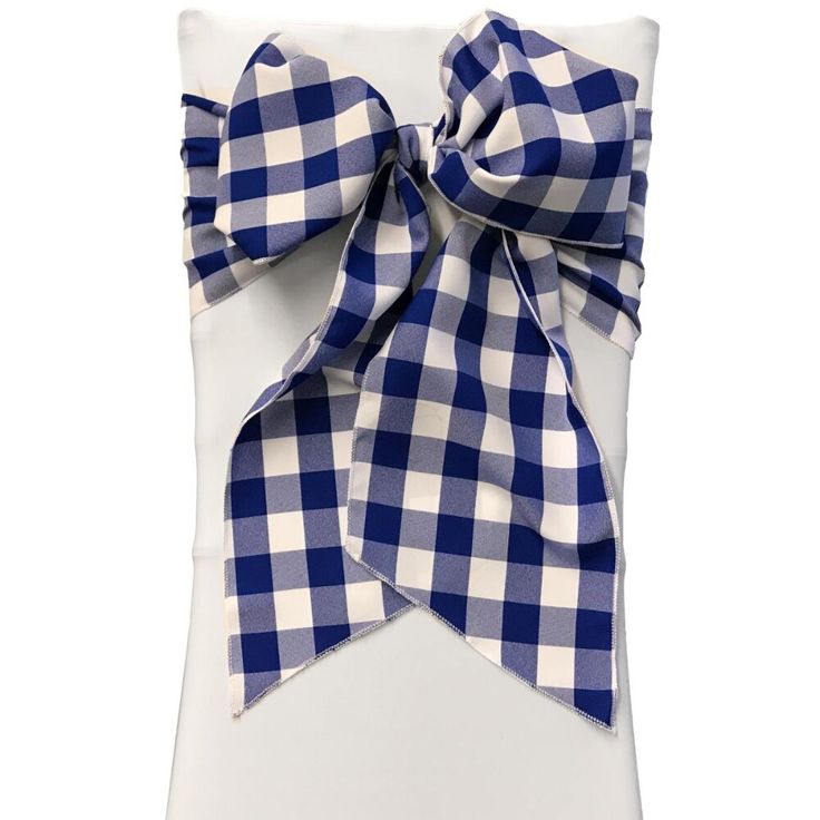 a blue and white checkered pillow with a large bow on the front of it