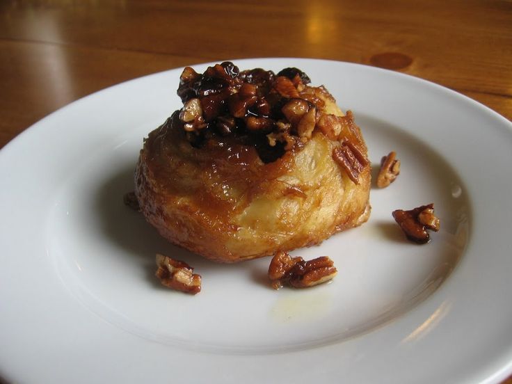 a white plate topped with a pastry covered in nuts