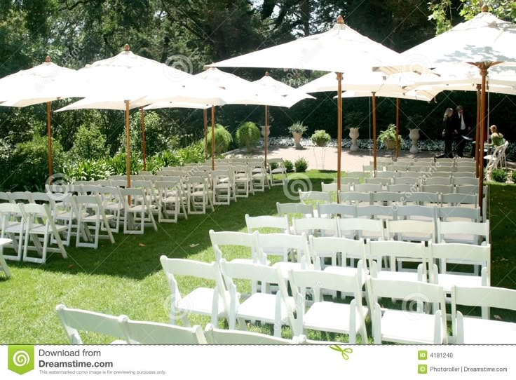 rows of white chairs and umbrellas set up for an outdoor ceremony