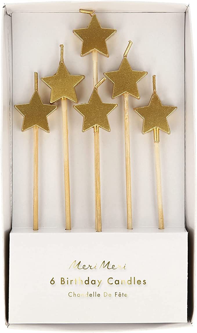 four gold star candles in a white box with the words new me's 8 birthday candles