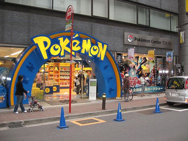 the entrance to a pokemon store with people walking by