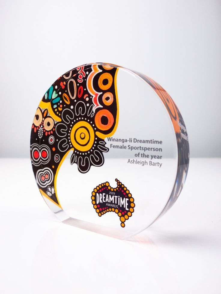 a glass award with an artistic design on the front and back side, sitting on a white surface