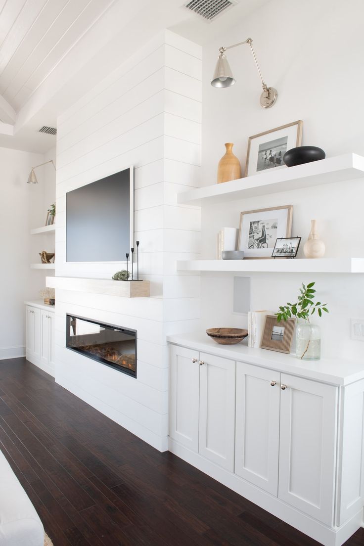 a living room filled with furniture and a flat screen tv mounted on a wall above a fireplace