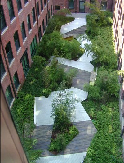 an aerial view of a building with trees and plants growing on the side of it