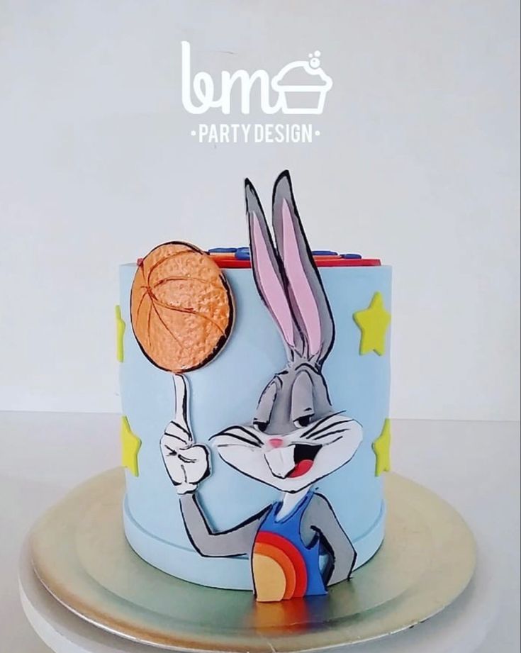 a rabbit holding a basketball on top of a cake