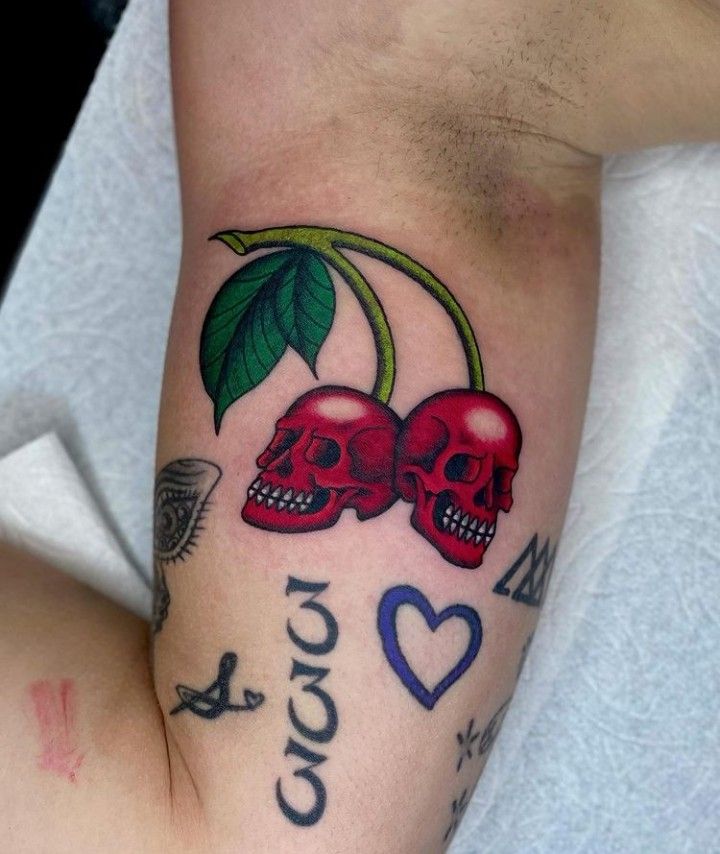 two skulls with hearts and leaves on their arm