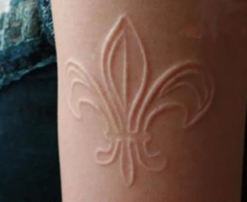 a close up of a person's leg with a tattoo on it and a fleur de lis design