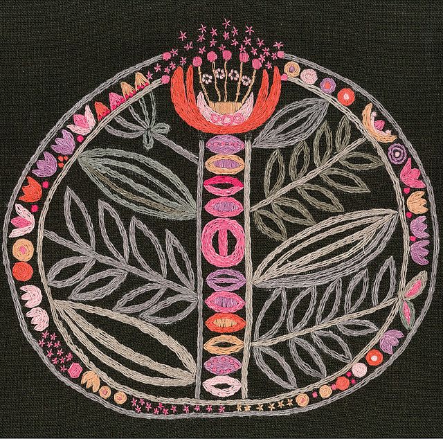 a circular design with flowers and leaves in the center on a black background that has stars